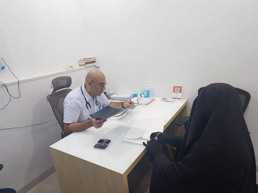 Doctor reading through a visitor’s report at a consultation desk