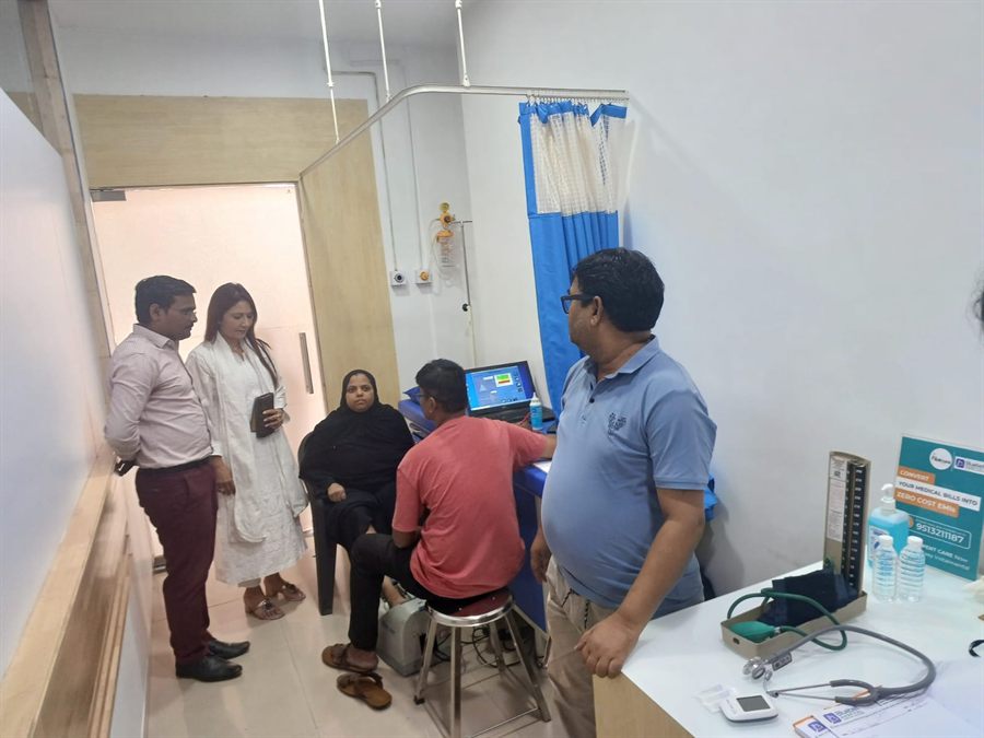 Visitors waiting along a hospital corridor during a check-up camp