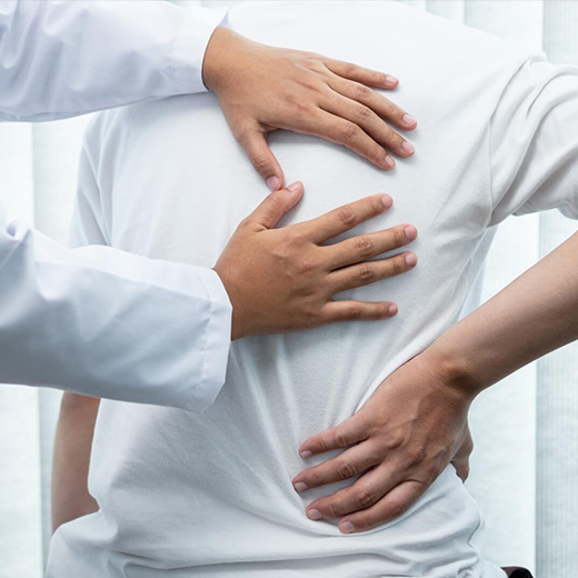 Physiotherapist supporting a patient’s lower back during treatment
